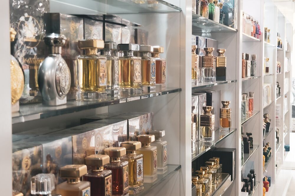 Glasregale mit goldenen und bernsteinfarbenen Parfumflakons